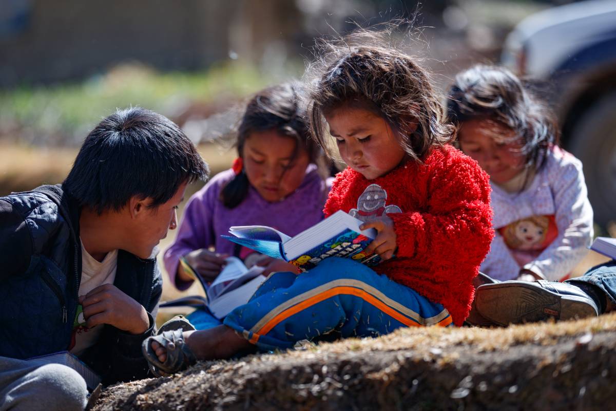 Four kids in Peru reading their Bibles outside.